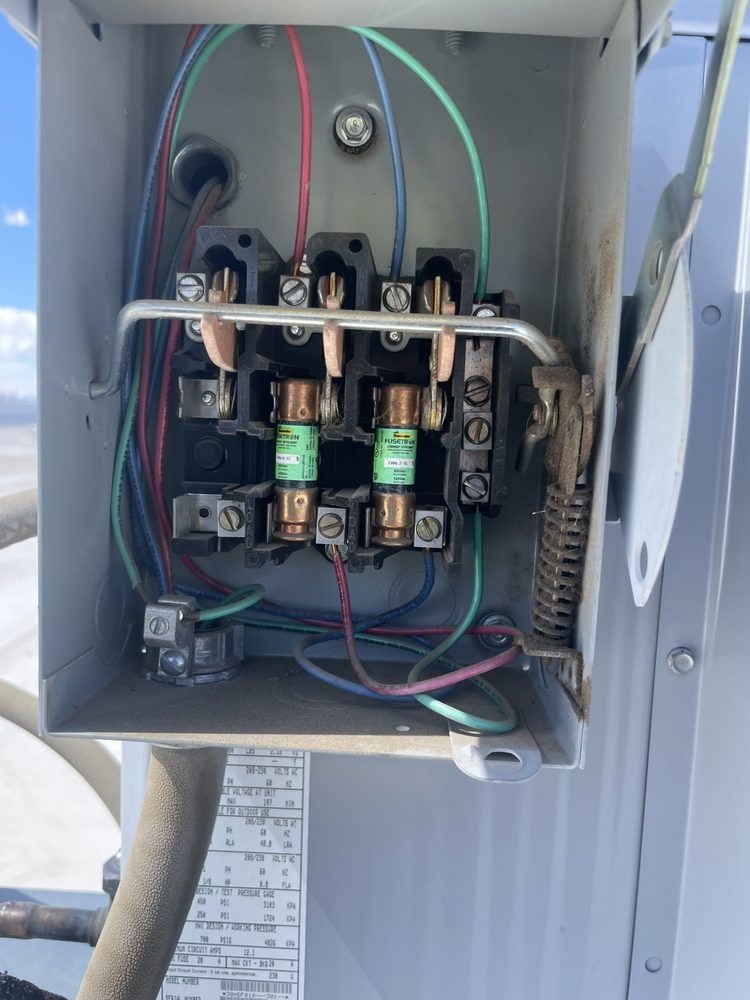 An open fused electrical disconnect inspected during an air conditioner repair by Temperature Select Air.