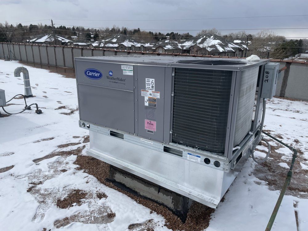 A Carrier WeatherMaker rooftop unit serviced in winter conditions by Temperature Select Air.